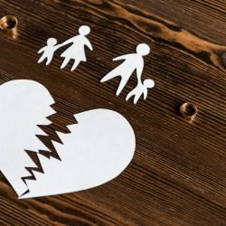 close-up-shot-of-teared-heart-with-family-and-engagement-rings-on-wooden-table-divorce-concept.jpg